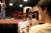 Junior Matt Stimmel sits off stage and follows along in his script as fellow Union students rehearse for <em>The Dining Room</em>, while director Chris Bennett (left) guides Senior Jill Casey in her scence. - Photo by Neisha Fuson