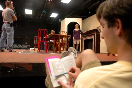 Junior Matt Stimmel sits off stage and follows along in his script as fellow Union students rehearse for <em>The Dining Room</em>, while director Chris Bennett (left) guides Senior Jill Casey in her scence.