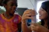 Sophomore Sarah Kim shows a girl how to make a paper towel roll rocket at a Boys and Girls Club meeting.  - Photo by Neisha Fuson