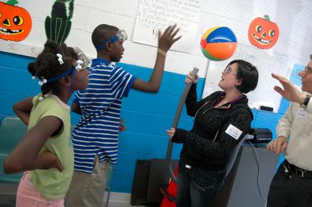 Michelle Thornhill gives a demonstration at the physics table at a Boys and Girls Club. 