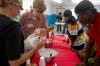 Children watch as Alicia Bennett and Kent Willis prepare to make ice cream at a Boys and Girls Club.  - Photo by Neisha Fuson