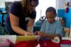 Kathleen Cooper helps a boy with a paper towel rocket at a Boys and Girls Club.  - Photo by Neisha Fuson