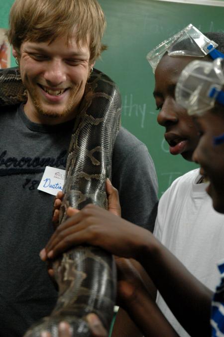 Dustin Scott smiles as children from a Boys and Girls Club ask all sorts of questions about his snake.
