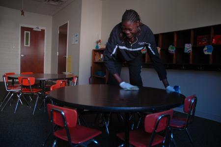 Freshman Lady Bulldog Beatrice Awino cleans some tables in J-Crib Ministries for this year's service project on Day of Remembrance. 