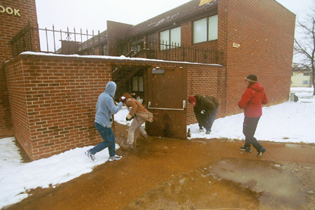 Several students ambush a student with snowballs before he runs back into Watters Complex.