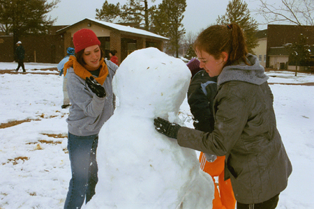 Freshmen Beth Pierce and Cindy Keegan work hard at building their first snowman for the year 2003.  