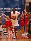 Freshman Zeinab Chan runs back down the court during the NAIA while the cheerleader's yell in the background.  - Photo by Neisha Fuson