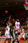 Josephine Owino smacks down a shot by a University of Sciences and Arts player during the first round game of the NAIA tournament. - Photo by Kristi McMurry