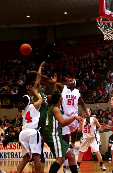 Josephine Owino smacks down a shot by a University of Sciences and Arts player during the first round game of the NAIA tournament.