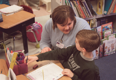 Assignment: Alison Oshel/Student Teacher - According to Oshel, working with students one on one and giving them individual attention is a quality every teacher should possess. In this photo she helps Logan Martin with his assignment.