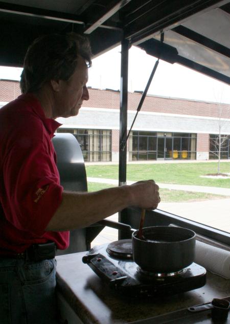Rick Dalton stirs a special sauce for the bar-b-que that his team at Gwatney Chevrolet is so good at cooking.  Gwatney Chevrolet provided and prepared a delicious barbeque lunch for Union faculty, staff, and students.