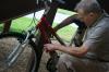 Ed Huthman, grandfather of Emily Huthman, patiently figures out his granddaughter's bicycle lock during move-in day for new students.  Huthman says he has moved several children and grandchildren into college, but &ldquo;this is the first time people have been standing around to help.&rdquo; - Photo by Kristi McMurry