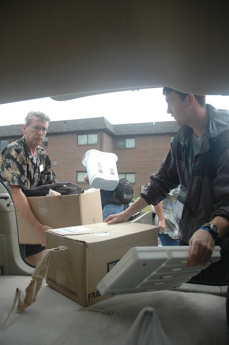 Richard Wells, dean of the chapel, and Junior Peter Boedecker unload a student's belongings during freshmen move-in day. 