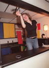 Assignment: Trading Spaces - Junior Emily Jonas, English major, puts the finishing touches on the kitchen in Watters Commons. - Photo by Kristen Hiller