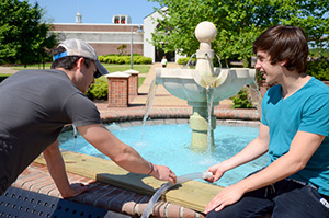 Engineering students working on a project by the fountain