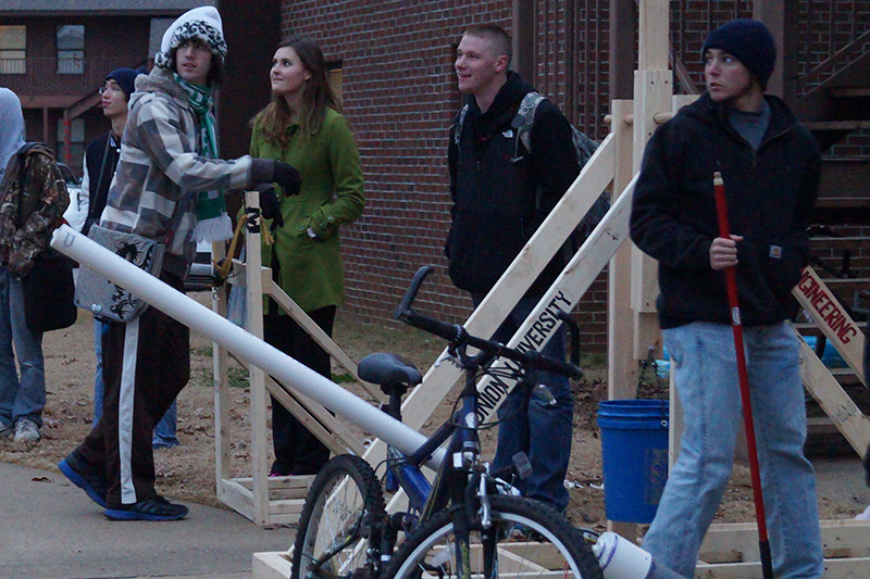 A group of students tests out a water balloon launcher in EGR 101