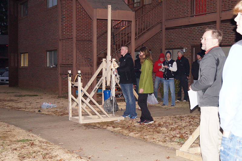 A group of students tests out a water balloon launcher in EGR 101