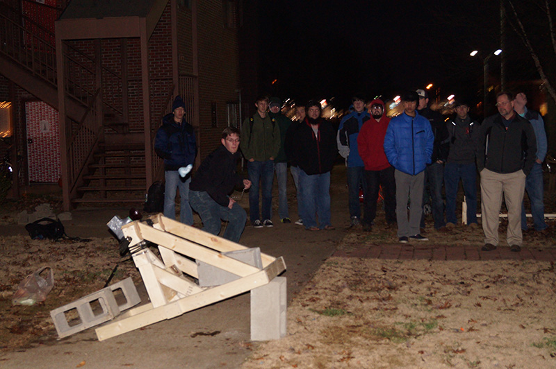 A group of students tests out a water balloon launcher in EGR 101