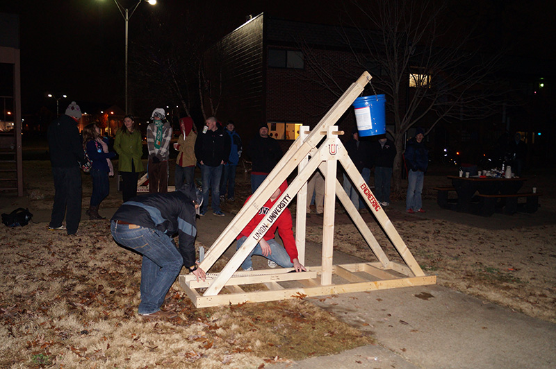 A group of students tests out a water balloon launcher in EGR 101