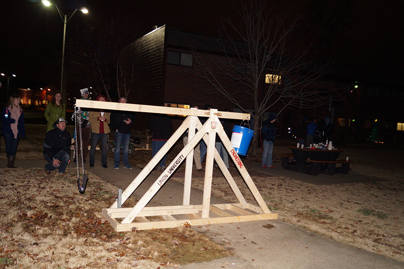 A group of students tests out a water balloon launcher in EGR 101