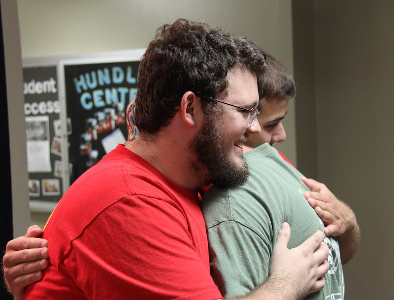 Phi Alpha Theta President Nicholas Hancock (front) and Vice President Allen Bradley (back) embrace a classmate at the Student Organizations Fair on August 17, 2015.