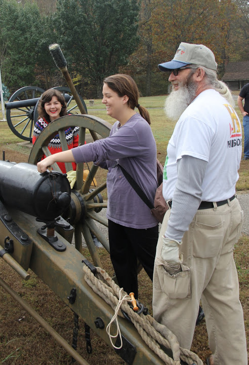 Emily Littleton (center) wears an artillery thumbstall as she stops the barrel vent of a just-fired cannon on November 3, 2015. Others in the photo are Priscilla Porter (left) and James Price.