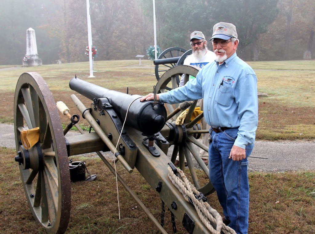 Britton Lane Battlefield Association President Jim Weaver explains the different steps that go into the firing of a cannon during the history department's community service project at Britton's Lane on November 3, 2015. James Price of the battlefield association stands behind him.