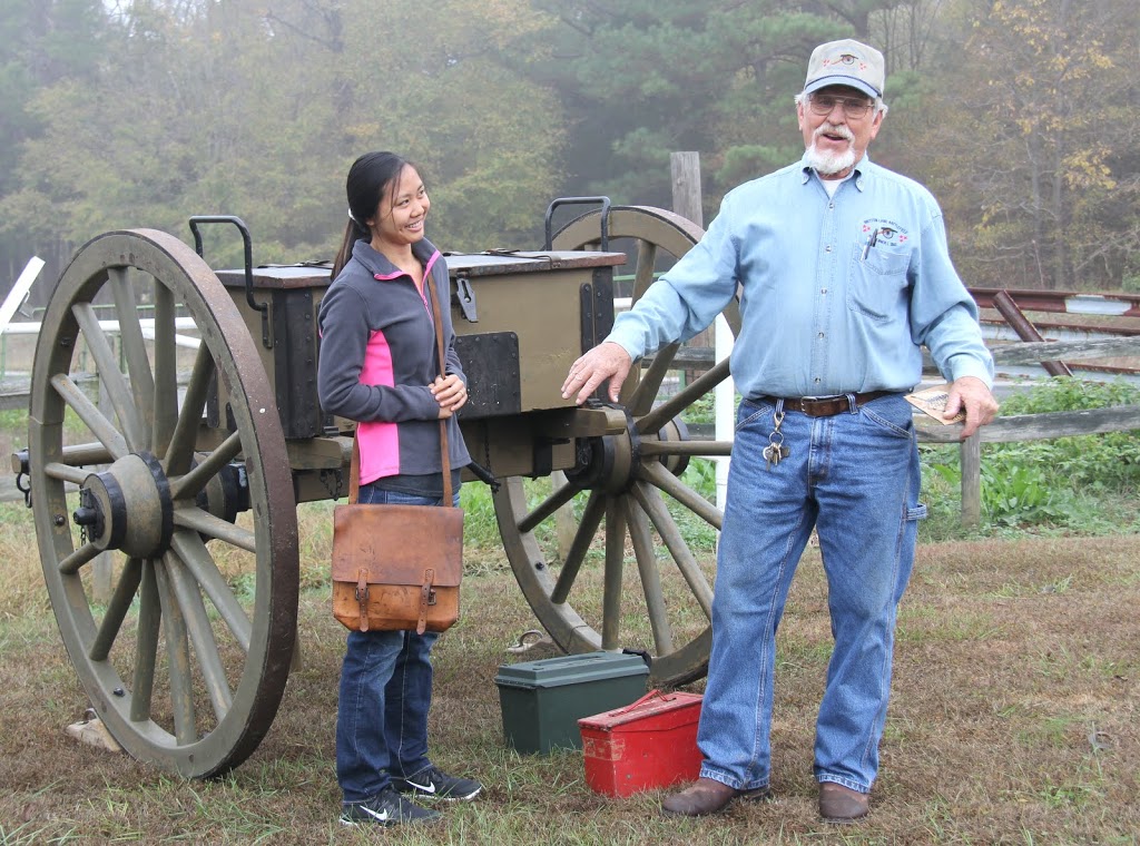 Katherine Cheshire, preparing to carry a packet of gunpowder to a powder receiver, listens as Britton Lane Battlefield Association President Jim Weaver talks about the importance of her task on November 3, 2015.