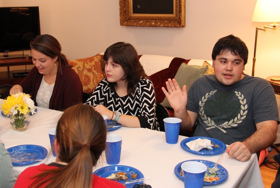 Attendees at the Phi Alpha Theta pizza party at Dr. Stephen Carls's home on October 16, 2015, enjoy table conversation together. They are: (facing the camera, left to right) Emily Littleton, Priscilla Porter, and Ashton Hostetler.