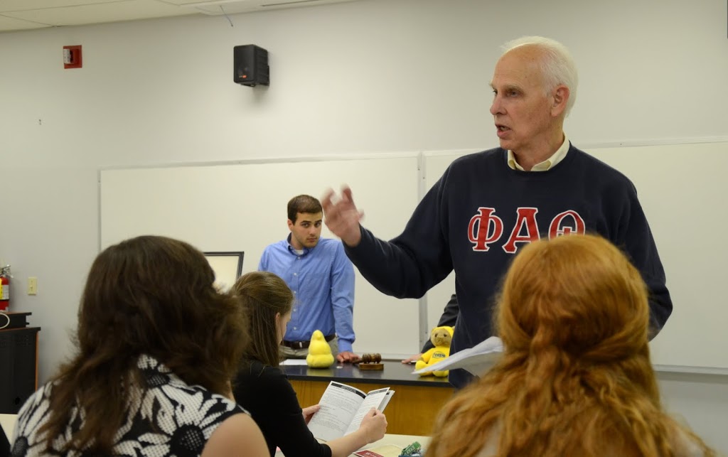 Dr. Stephen Carls (standing on the right) talks about the 2016 Phi Alpha Theta Biennial Convention at the Delta-Psi chapter's plenary meeting on September 14, 2015. Chapter Vice President Allen Bradley (wearing blue shirt) stands in the background. Photo by Elizabeth Wilson