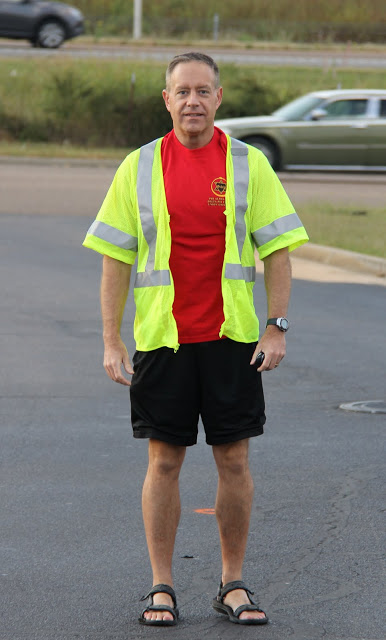 Dr. Henry Allen, a Phi Alpha Theta volunteer at the Racing So They Can Ride event on September 19, 2015,  stands at his post along the race course to cheer on and guide runners during the competition.