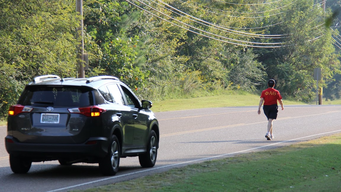Dr. Alice-Catherine Carls, with the protection of a volunteer race vehicle, advances toward the three-quarters mark in the 5k race at the Racing So They Can Ride event on September 19, 2015.