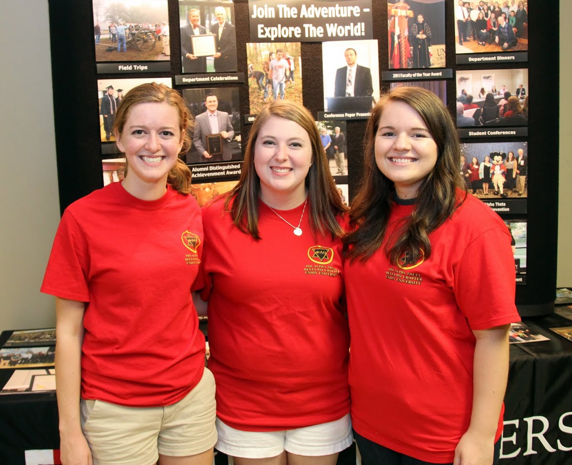 Beth Adams (left to right), Kathryn Mitchell, and Jordan Sellers stand in front of the history department display at the Student Organizations Fair on August 22, 2016.