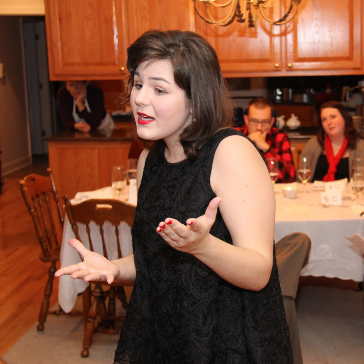 Phi Alpha Theta member Priscilla Porter performs an excerpt from Don Zolidis's Mall Santa Saves the Day as part of the program at the history department's French Christmas dinner on December 10, 2016.