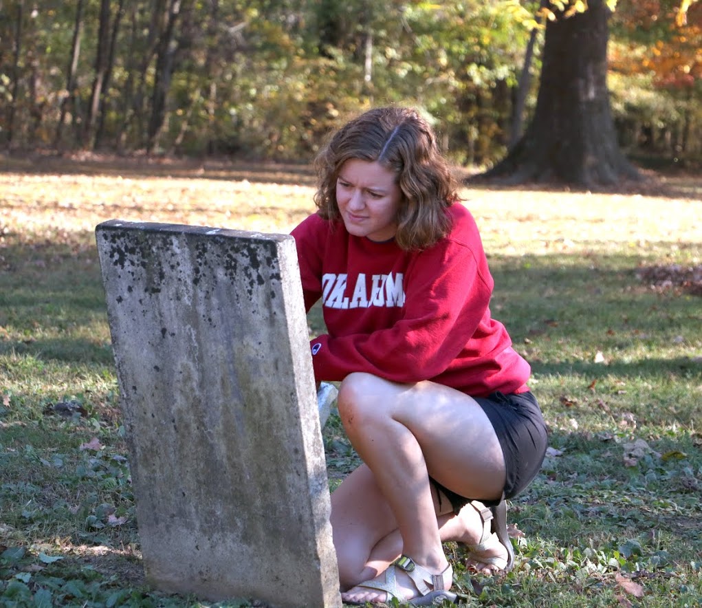 Beth Adams cleans a tombstone as a part of the Phi Alpha Theta community service project at Salem Cemetery on November 1, 2016. Photo by Elizabeth Wilson