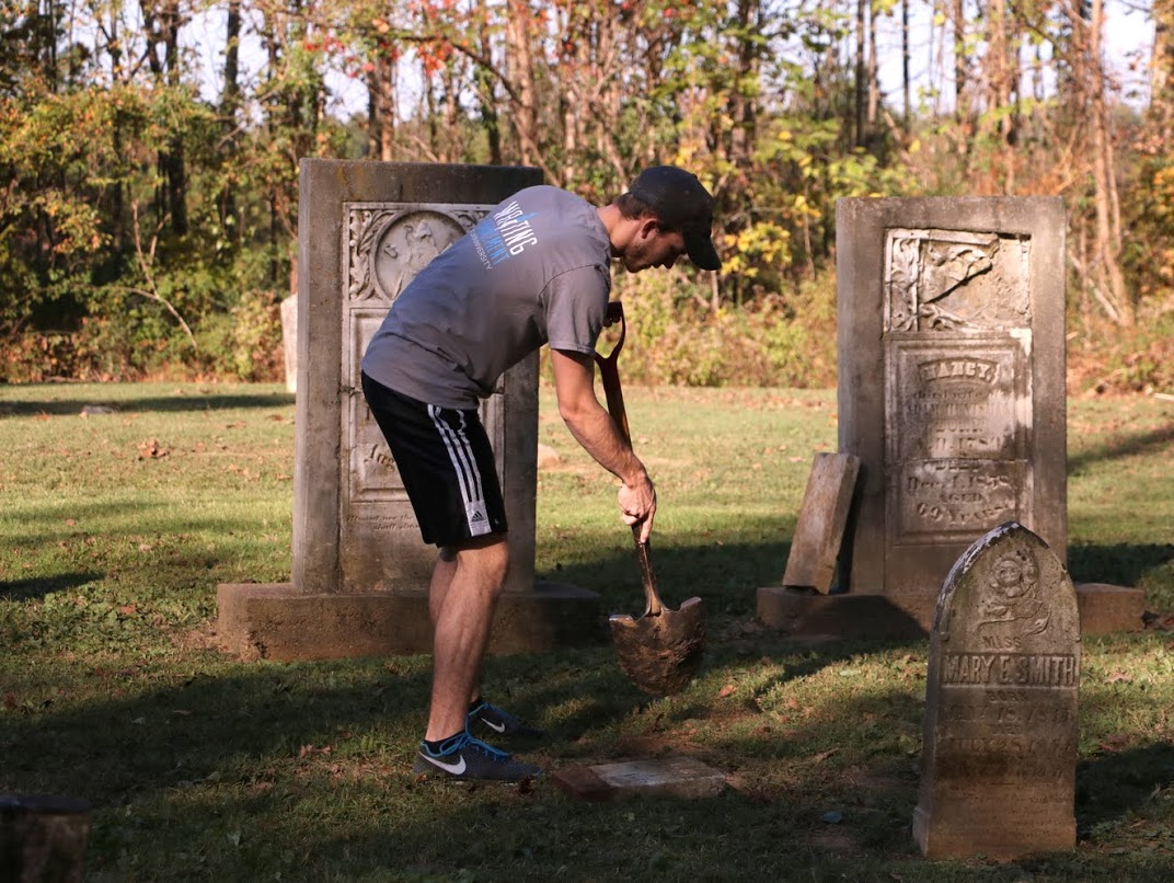 Seth Reid straightens out a gravestone at Salem Cemetery on November 1, 2016. Photo by Elizabeth Wilson