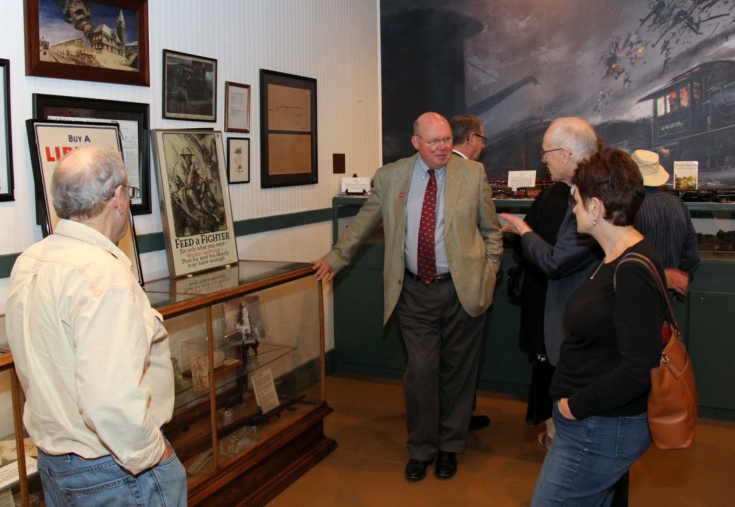 Tennessee Great War Commissioner Andy Pouncey (second from left, wearing sport coat) talks to Great War Symposium attendees about his collection of posters, weapons, and other World War I items on display at Jackson's Casey Jones Railroad Museum on November 5, 2016.