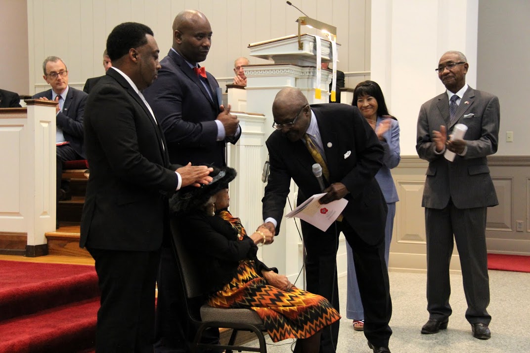 Harrell Carter, President of the Madison County NAACP, congratulates Mrs. Katie Cobb as the widow of a World War I veteran during a special ceremony at the Great War commemoration program at Jackson's First Presbyterian Church on November 4, 2016. Standing behind him are Tennessee Department of Veterans Services Commissioner Many-Bears Grinder and Tennessee State Representative Johnny Shaw. Standing behind Mrs. Cobb are two of her grandsons.