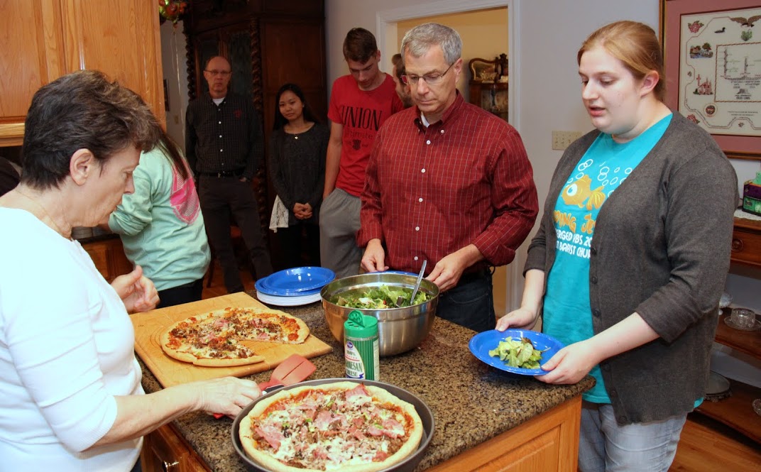 Attendees at the Phi Alpha Theta Best Chapter Award pizza party on October 21, 2016, stand in line to get pizza and a tossed salad. They are: (left to right) Robert Briley (furthest back in the photo) Katherine Cheshire, Stephen Lewoczko, Seth Reid (barely visible in the photo), Dr. David Thomas, and Susannah Murphine. Party hostess Dr. Alice-Catherine Carls (left) helps serve the pizza.