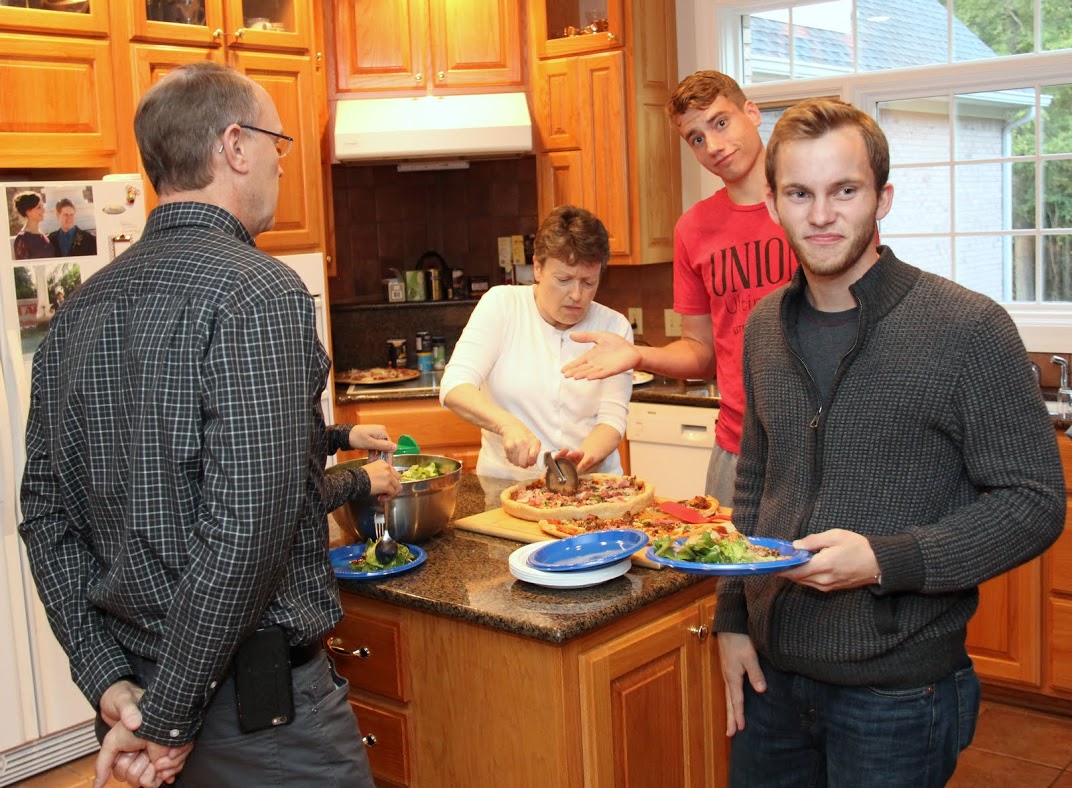Phi Alpha Theta member Seth Reid (right) leaves the food area with his food plate at the Phi Alpha Theta Best Chapter Award pizza party on October 21, 2016. Stephen Lewoczko is behind him. Robert Briley (back to camera) waits in the food line while party hostess Dr. Alice-Catherine Carls cuts a pizza.