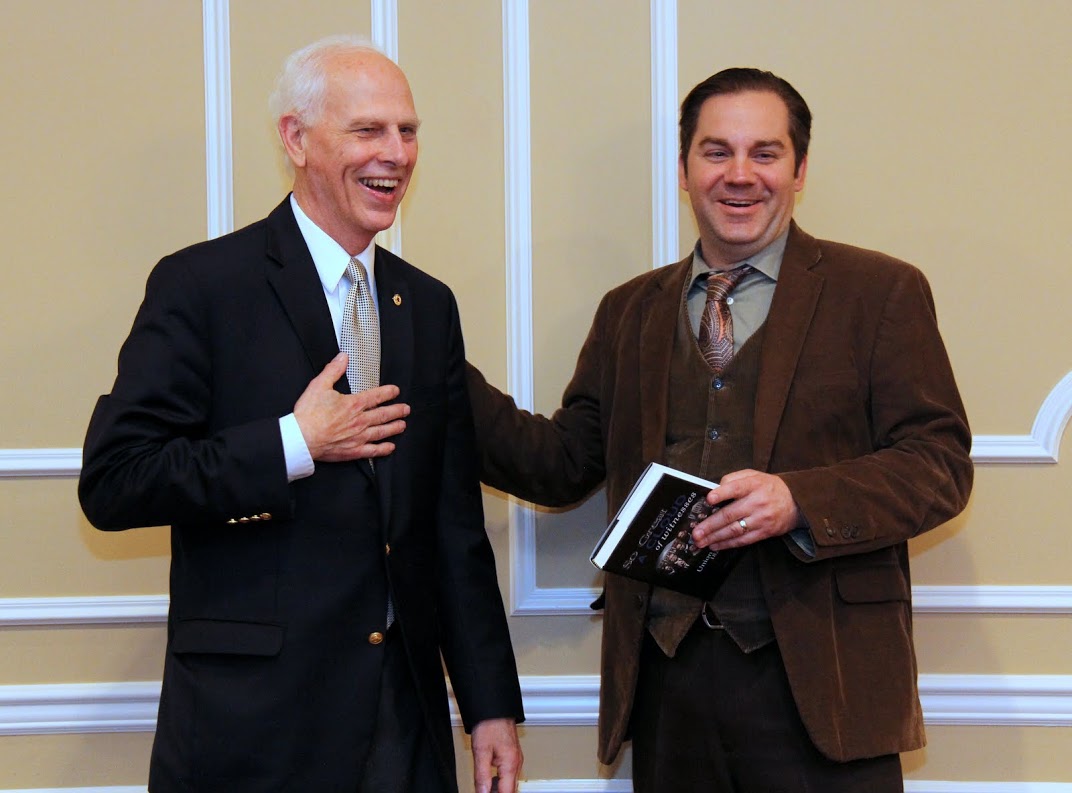 Drs. Stephen Carls (left) and Sean McMeekin enjoy a light moment together during the presentation of a book about the history of Union University to Professor McMeekin at a dinner in his honor on October 3, 2016.