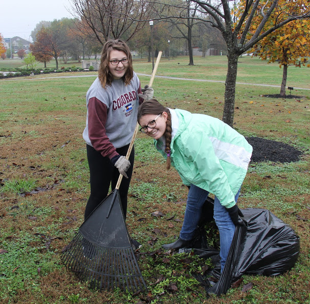 SaraBeth Conley (left) and Emily Summers gather up bush trimmings at Liberty Garden Park on November 7, 2017.