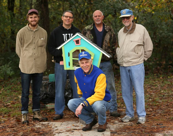 Participants in the history department's community service project stand by a Little Free Library at Liberty Garden Park. Dr. Stephen Carls kneels in front of the library; standing behind him are (left to right) Luke Sower, Dr. Keith Bates, Dr. Kelvin Moore, and Dr. Terry Lindley. Carls's daughter Elizabeth Weber constructed the library for the park in early 2017. Photo by Kristi Woody