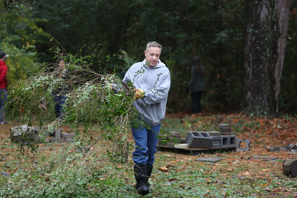 Dr. Henry Allen carries some branches for loading onto a dump truck at the History Department/Phi Alpha Theta community service project at Liberty Garden Park on November 7, 2017. Photo by Kristi Woody