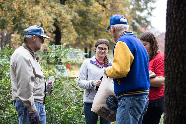 Dr. Stephen Carls (second from right) hands out snacks to Emily Summers (third from right) and Jessica Barton (right) at the history department's community service project at Liberty Garden Park, while Dr. Terry Lindley observes. Photo by Janelle Vest