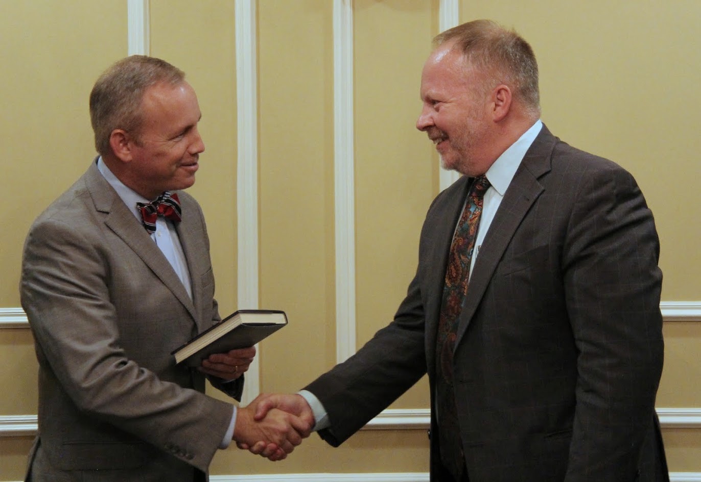 Dr. Bruce Gordon (right) presents a copy of his book JOHN CALVIN'S INSTITUTES OF THE CHRISTIAN RELIGION: A BIOGRAPHY to Union University President Samuel W. Dub Oliver at at dinner in Gordon's honor on October 19, 2017.