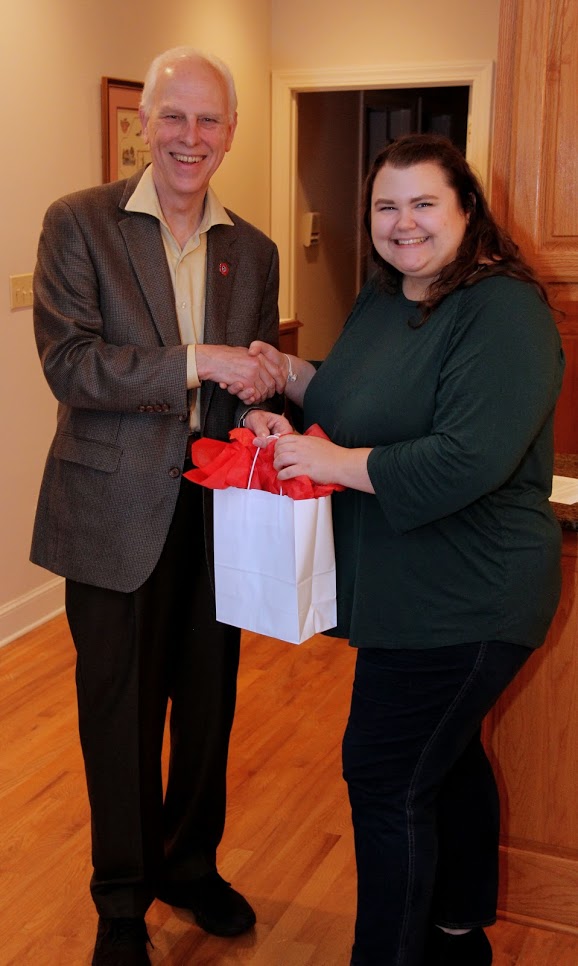 Dr. Stephen Carls presents a graduation bag to Phi Alpha Theta member Jessica Barton at the history department's French Christmas dinner on December 8, 2018.