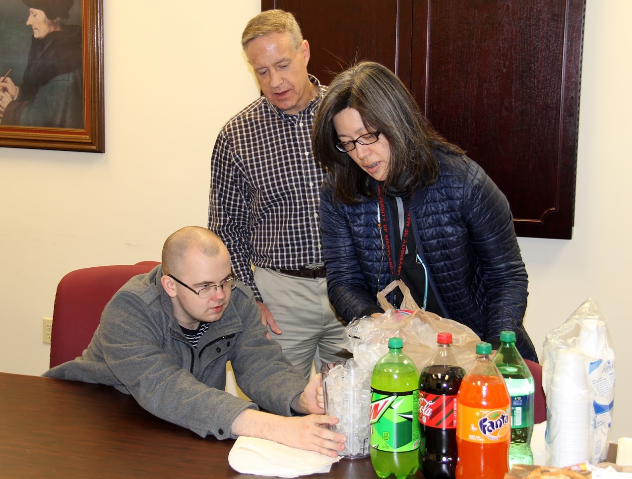 History club member Will Choate (seated) helps Haelim Allen get ice ready for the drinks at the club's movie night party on November 9, 2018. Dr. Henry Allen (standing) observes.