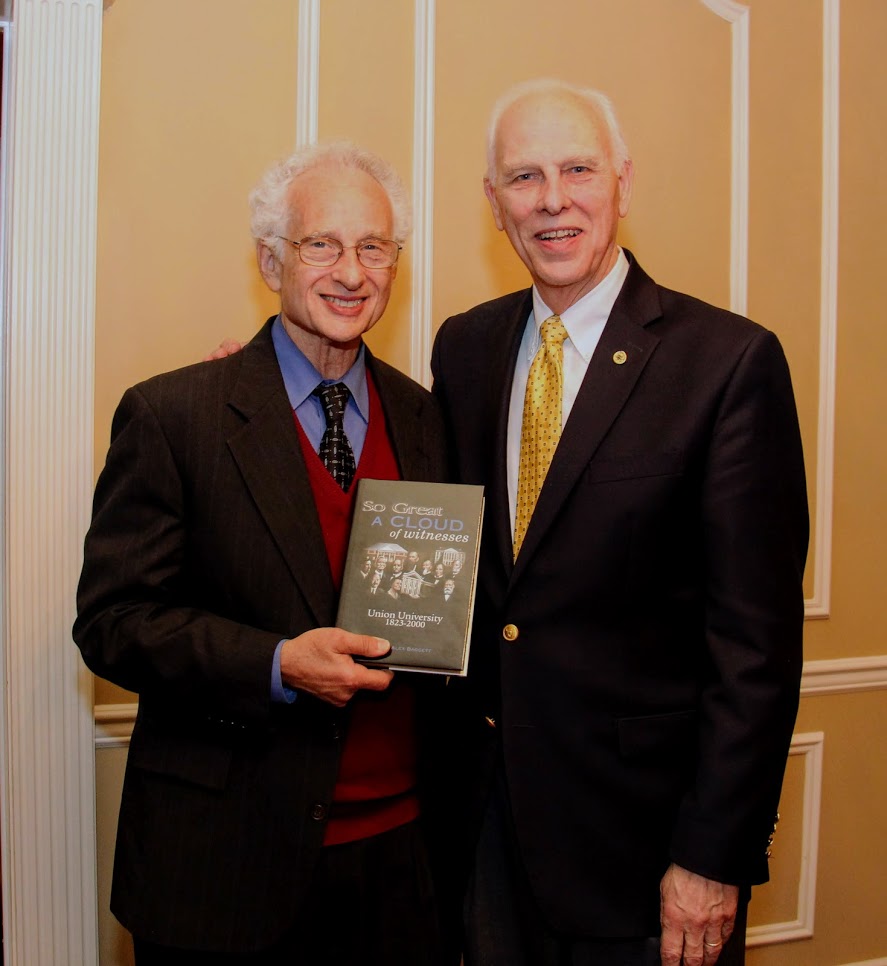 Dr. Melvyn Leffler, the 2018 Carls-Schwerdfeger History Lecturer, accepts a book from Dr. Stephen Carls at a dinner in Leffler's honor on October 22.