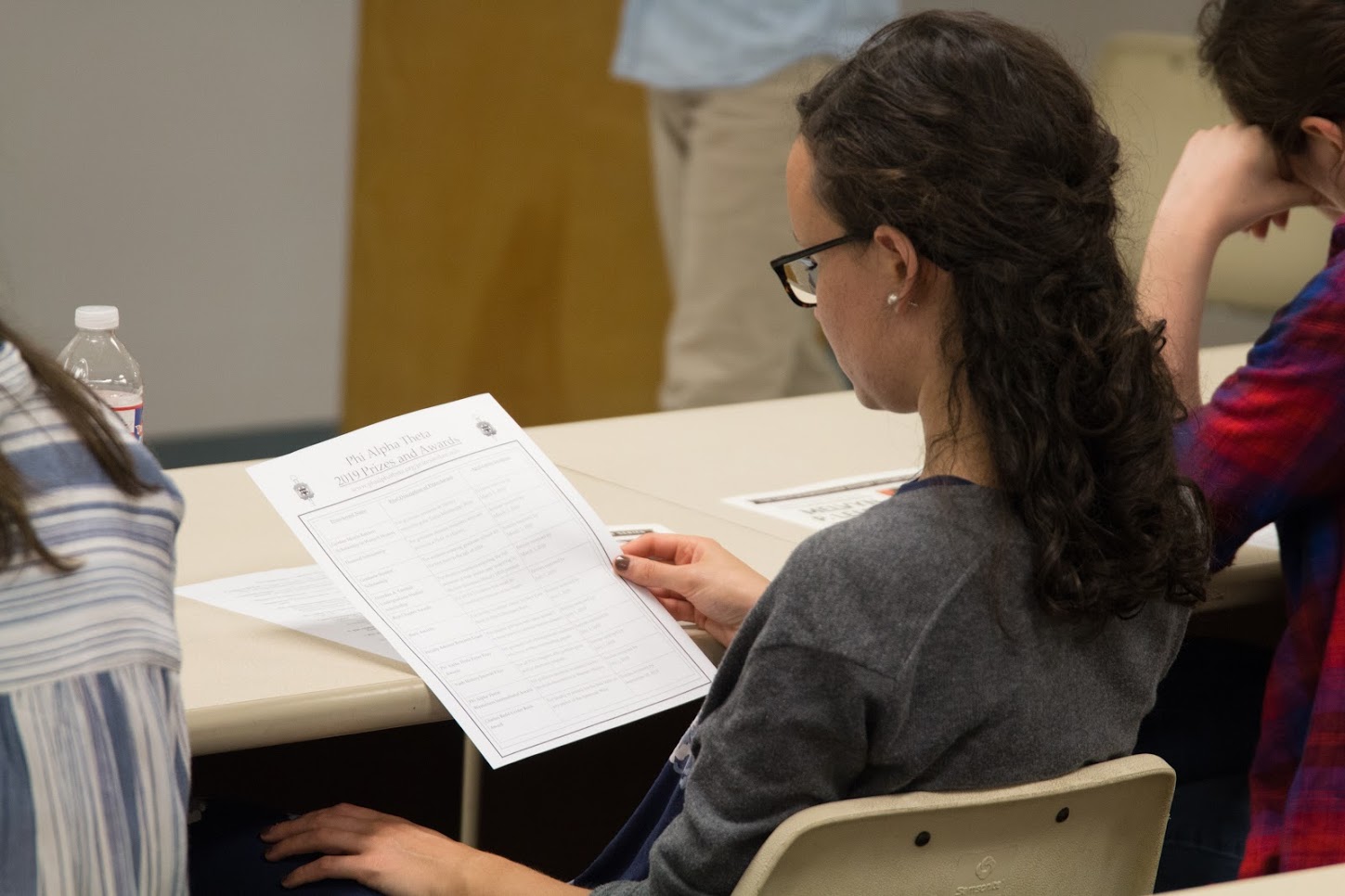 Phi Alpha Theta member Lillie Salazar looks at a Phi Alpha Theta 2019 Prizes and Awards sheet during the Delta-Psi chapter's fall semester plenary meeting on September 20, 2018. Photo by Lynn Tucker
